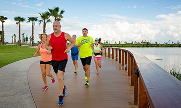 Group running on trail along lake in Waterset.